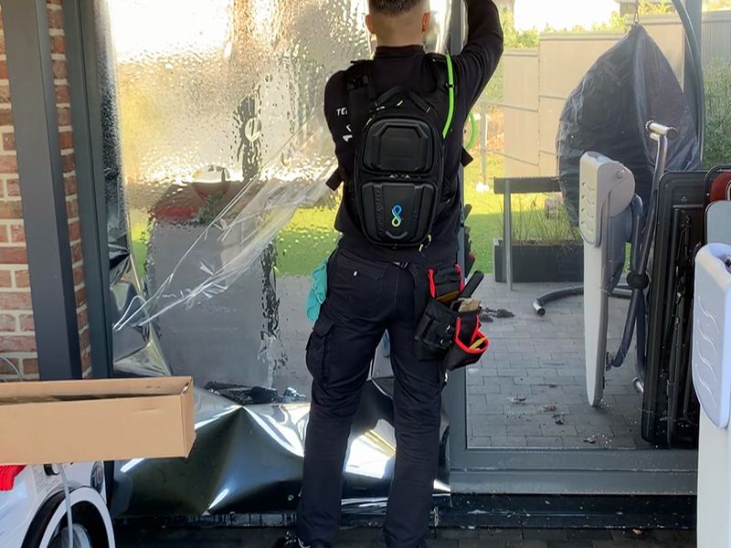 Pose du film miroir extérieur sur une porte-fenêtre de la terrasse, à Hanzinne