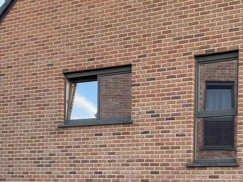 Façade en briques et fenêtres équipées d'un film miroir extérieur